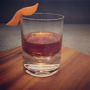 An image of the Madame Mustache cocktail submitted by n0tquitethere that contains Agricole Rhum, Drambuie, Cynar, Angostura Bitters and Grapefruit